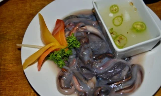 Du khách bắt sâu dài nửa mét lúc nhúc trong gỗ rồi cho ngay miệng thưởng thức