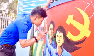 Lê Văn Đông - Bí thư Chi đoàn xóm 1, xã Nghĩa Thuận, thị xã Thái Hòa (Nghệ An) vẽ tranh bích họa tại trường mầm non của xã