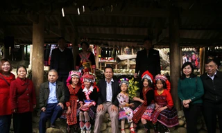 Du khách chụp ảnh kỉ niệm cùng các bé gái người Mông ở chợ phiên Sin Suối Hồ. Ảnh: LỘC LIÊN