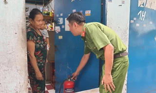 Công an TPHCM hướng dẫn người dân sử dụng bình chữa cháy tại phòng trọ ở quận Tân Phú. Ảnh: Hoàng Thuận