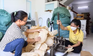Chị Thư áo kẻ trong xưởng sản xuất sản phẩm từ xơ mướp