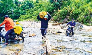 Đoàn viên thanh niên Huyện Đoàn Nam Giang băng rừng, lội suối vận chuyển vật liệu xây “Mái ấm biên cương”. Ảnh: Nguyễn Thành