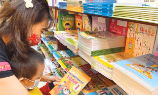 Giá SGK mới cao, phụ huynh thêm gánh nặng khi cho con đi học. Ảnh: Như Ý
