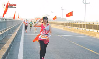 Chị Trần Thị Phượng xúc động khi chạy giữa hai hàng cờ Tổ quốc tại Tiền Phong Marathon Phú Yên 