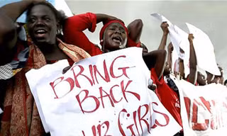 Thân nhân các nữ sinh bị Boko Haram bắt cóc biểu tình yêu cầu chính phủ Nigeria tìm kiếm và giải cứu con của họ. Ảnh: Telegraph.