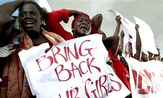 Thân nhân các nữ sinh bị Boko Haram bắt cóc biểu tình yêu cầu chính phủ Nigeria tìm kiếm và giải cứu con của họ. Ảnh: Telegraph.