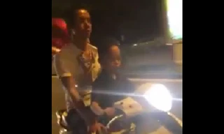 Bé trai 7 tuổi lái xe tay ga chở bố trên đường phố