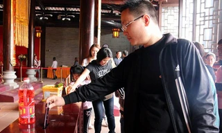 Một người đàn ông bỏ cả chiếc iPhone 6 vào hòm công đức.