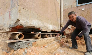 Một công nhân đặt tấm ván lên những ống sắt ngắn trong khe tường của một bệnh viên ở thành phố Trịnh Châu, tỉnh Hà Nam, Trung Quốc hôm 8/4.