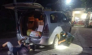 Cán bộ chốt kiểm soát dịch COVID-19 vá xe trong đêm cho người đi đường