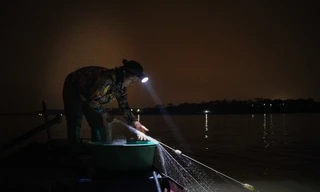 Nữ ngư phủ Trần Thị Hiền, hộ dân sinh sống ở xóm chài Vạn Thắng Lợi (xã Hồng Hà, huyện Đan Phượng, Hà Nội) đánh cá đêm trên sông Hồng.