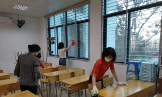 Giáo viên Trường THCS Kim Giang (Hà Nội) lau bàn ghế học sinh bằng dung dịch khử khuẩn chiều 26/2 