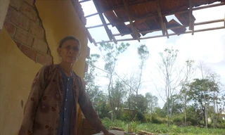 Bà Trần Thị Rê bên mảng tường còn sót lại với những chân nhang còn nguyên lành ảnh: Tr.T 