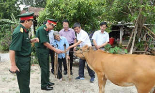Trung tướng Nguyễn Đức Soát, Chủ tịch Hội Hỗ trợ khắc phục hậu quả bom mìn Việt Nam, tặng bò cho nạn nhân bom mìn tại huyện Bố Trạch, tỉnh Quảng Bình. Ảnh: L.A 