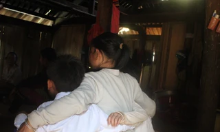 Dìu ôm hai đứa con trong căn nhà vừa được tu sửa lại