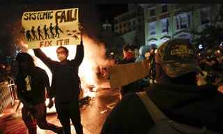  Một người biểu tình Mỹ giương tấm biển có khẩu hiệu “Systemic Fail” (Thất bại hệ thống) gần Nhà Trắng ngày 31/5 ảnh: AP 