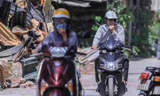 Người dân đi qua hiện trường vụ cháy phải bịt mũi vì mùi khét đậm đặc. Ảnh: Duy Phạm 