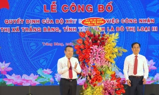 Bí thư Thị ủy Trảng Bàng Đoàn Minh Long (phải) nhận hoa chúc mừng tại buổi lễ. Ảnh: Y.N