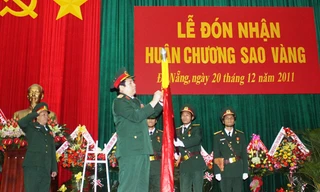 Đại tướng Phùng Quang Thanh gắn Huân chương Sao Vàng lên quân kỳ quyết thắng của Quân khu 5. Ảnh: Nguyễn Huy
