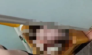 Bé trai được nhân viên y tế bế ra từ thùng rác (ảnh cắt từ clip)