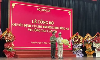 Thượng tá Nguyễn Quang Huyên (bìa phải) nhận Quyết định, hoa chúc mừng. Ảnh: Duy Chiến 