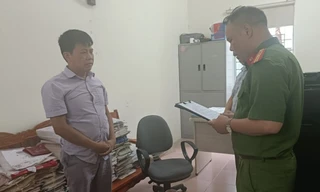 Đối tượng Nông Văn Thuận (bìa trái) nghe quyết định khởi tố bị can. Ảnh: CB