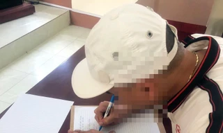 Ông Đ viết tường trình tại cơ quan công an. Ảnh: TL