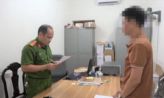 Ông L.V.Q (bìa phải) nghe quyết định khởi tố bị can, khởi tố vụ án trốn thuế -Ảnh: TL