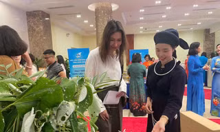 Chị Lăng Thị Thơ ( áo chàm) giới thiệu đặc sản xứ Lạng với du khách. 