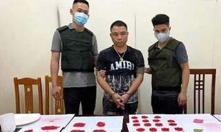 Đối tượng Mạnh (giữa) cùng tang vật bị bắt giữ -Ảnh: A. Khoa