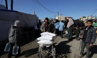 Một người Palestine đang chở bột mỳ được cơ quan cứu trợ của Liên Hợp quốc UNRWA phân phát ở Dải Gaza ngày 1/2. (Ảnh: Reuters)