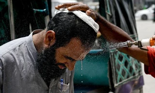 Một người đàn ông Pakistan được phun nước vào mặt cho đỡ nóng. (Ảnh: Getty)