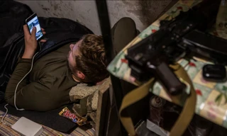 Một người lính Ukraine dùng điện thoại di động khi đang nghỉ tại địa điểm gần Bakhmut ngày 23/5. (Ảnh: Reuters)