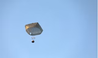 Một gói hàng cứu trợ được máy bay Mỹ thả xuống Dải Gaza bằng dù. (Ảnh: Reuters)