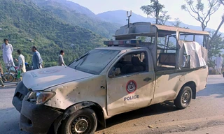 Chiếc xe của cảnh sát bị méo mó sau vụ đánh bom ở Pakistan ngày 22/9. (Ảnh: AP)