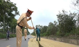 Cảnh sát giao thông nhắc nhở việc phơi thóc trên đường ở Hà Nội