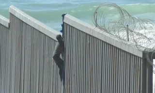Người di cư ở Mexico trèo tường biên giới để vào Mỹ