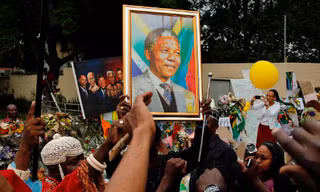 Người dân hát bên ngoài nhà cố tổng thống Nam Phi Nelson Mandela tại Johannesburg, hôm qua, mùng 9/12.