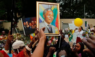 Người dân hát bên ngoài nhà cố tổng thống Nam Phi Nelson Mandela tại Johannesburg, hôm qua, mùng 9/12.