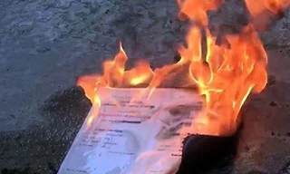 Bằng tốt nghiệp đại học bị đốt. Ảnh cắt từ clip.