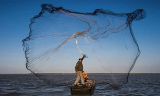 Một ngư dân quăng lưới đánh bắt ở tỉnh Giang Tô, Trung Quốc. (Ảnh: Xinhua)