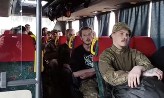 Ảnh cắt từ một video do Nga công bố ngày 17/5 cho thấy nhóm binh lính đầu hàng ở nhà máy thép Azovstal đang ngồi trên xe buýt để rời khỏi thành phố Mariupol