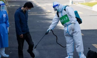 Một người dân được khử trùng sau khi rời khu cách ly tập trung ở Thượng Hải ngày 9/4. (Ảnh: AP)