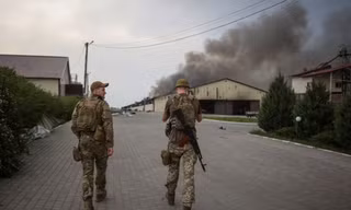 Hai lính Ukraine đang đi trên một con đường ở tỉnh Lugansk ngày 31/5. (Ảnh: Reuters)