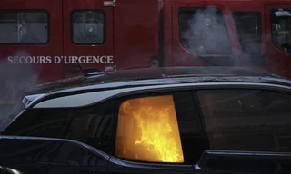 Một xe cứu hoả đậu gần chiếc xe bị đốt trong cuộc biểu tình vào ngày 5/12/2020. (Ảnh: AP)