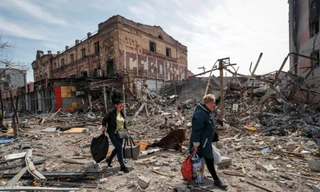 Người dân mang đồ rời khỏi thành phố Mariupol của Ukraine ngày 10/4. (Ảnh: Reuters)