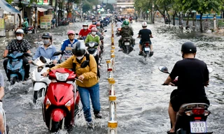 Mưa xối xả kéo dài, TPHCM ngập nặng khiến người dân vất vả lội nước về nhà