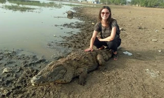 Nữ du khách Kristina Smith mạo hiểm cưỡi cá sấu khổng lồ chụp ảnh trong chuyến du lịch tới vùng miền đông Paga, Ghana.