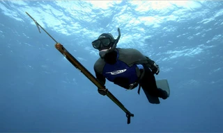 Một thợ săn cầm súng phóng xiên. Ảnh: NYTimes.