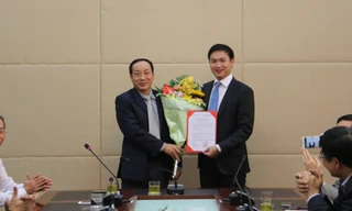 Thứ trưởng Nguyễn Hồng Trường trao Quyết định và tặng hoa cho ông Nguyễn Xuân Ảnh. 